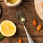 Complément alimentaire oméga-3 UNAE sous forme d’huile sur une cuillère avec citron et amandes