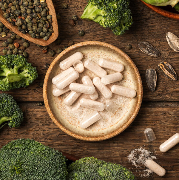 N-Acétylcystéine fermentée Complément N-acétylcystéine fermentée UNAE en gélules avec brocoli, graines et poudre sur fond bois