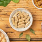 Complément alimentaire Equifer + B12 UNAE en gélules avec ingrédients végétaux sur fond bois