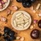Complément Jambes Légères UNAE en gélules avec raisins et ingrédients végétaux sur fond bois