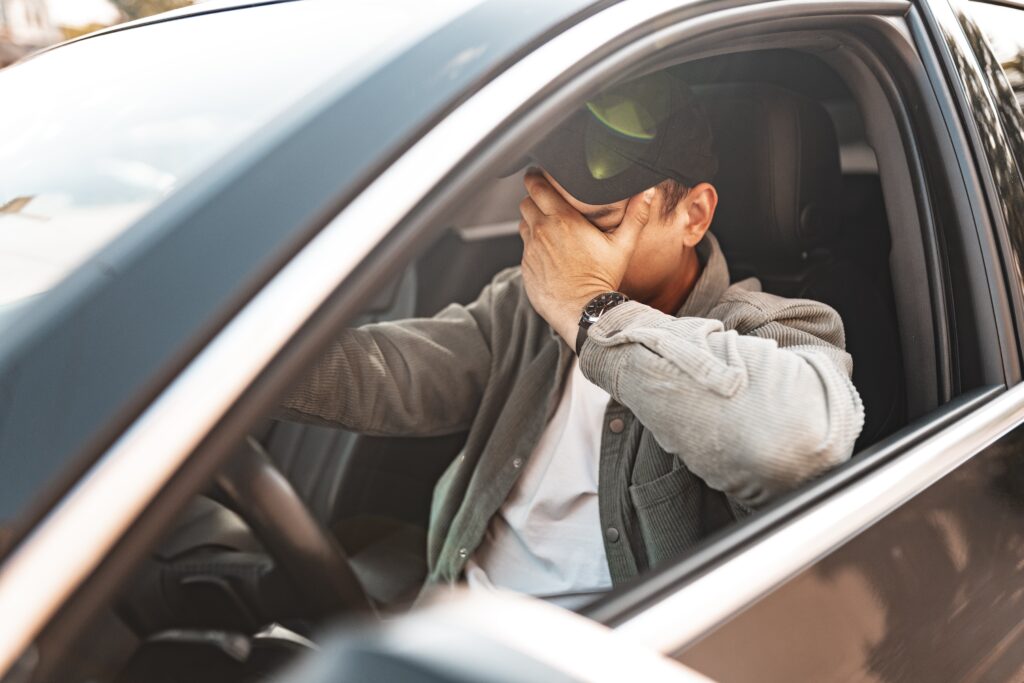 Conducteur fatigué se tenant le visage, en situation de somnolence au volant